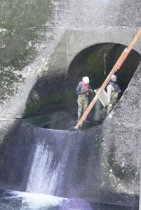 DNRC officials Robert Kinger and Brian Holling enter the dam's outlet tunnel at the bottom of the spillway at Painted Rocks Reservoir to make repairs to the dam. Michael Howell photo.