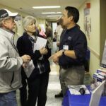 Pete Dunn, PT, Department Head of Marcus Daly Rehabilitation Center, visits with Mr. and Mrs. Carmody at the rehabilitation booth at the recent Health Fair. 
