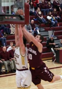 Florence’s Ryan Mangun goes for a dunk as a Troy player tries to stop him in the opening game of the Western B Divisional tournament. Jean Schurman photo