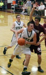 ach Gavlak drives for the basket against Butte Central’s Nate Bolstad as Stevensville’s Chris Lords looks on. Jean Schurman photo