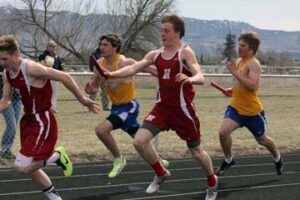 The Hamilton 400 relay team finished first and Victor’s team was second at the Florence/Darby Invitational. Shown here are Hamilton’s Kris Cleveland handing to Kyle Crossman and in the back, Victor’s Jesse Pearson handing to Nate Bishop. Jean Schurman photo