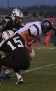 Stevensville’s Bryce Torrey (15) and Carson Katen (61) take down Corvallis’ Jayce Gilder during the Yellowjackets Homecoming game. Jean Schurman photo