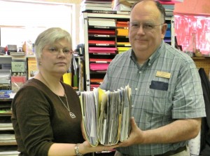 Carol and Al Mitchell, owners of The Paper Clip in downtown Hamilton, hold up a file of thank you letters received over the years from nonprofits and community organizations around the valley. Mitchell, who serves on the Hamilton City Council, told the council last week that this kind of community support could easily disappear if a large scale retail store, like Walmart, is ever constructed in the Hamilton Trade Area. “This file is filled with thank you letters from schools, scouts, nonprofits, and others over the last several years. This represents only the folks who sent thank you notes. Imagine the impact of the elimination of ten, fifteen, twenty or more small stores in the area,” said Mitchell. 