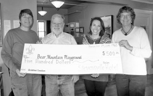 Robbie Springs and Gene Mim Mack, owners of the Stevensville Hotel, presented a check on Monday for $500 to Bear Mountain Playground representatives Renee Endicott and Sherri Ritter, along with a challenge to other businesses to donate to this worthy project that will benefit Stevensville’s children for years to come. Jean Schurman photo.