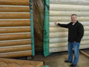 Rocky Mountain Homes President Tim Rybiski, in the shop where panels with log siding are stained and chinked.