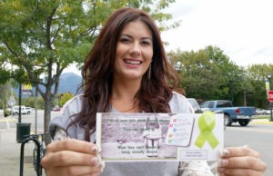 Tara Lyons hands out cards containing critical information for children and adults about sexual abuse and including the Abuse Hotline number. Jean Schurman photo.