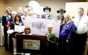 The Darby Rodeo Association and Tough Enough to Wear Pink teamed up to donate  $16,000 to the Aid for Mammography Fund as well as an original piece of art by KJ Kahnle which will hang in the Imagery Department. Shown, standing l to r: Amy James-Linton, MDMH; Barb Anderson, Soroptimist; Judy Rothie, MDMH; Bob Whalen, First Security Bank; Dr. Lance Pysher, MDMH; Arlene Hollingsworth Tunny, Soroptimist; Dr. John Harland, Cal Ruark, Jean Schurman, John Bartos; kneeling: Kathy Miller of the Imagery Department, and KJ Kahnle. 