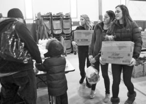 Florence students Destini Greer, Shay Waldbillig, and Kristin Hall carried food boxes out for people at the Pantry Partners Food Box Give-Away. Jean Schurman photo.