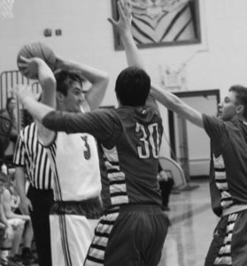 Zach McCrossin of Darby looks for an open teammate as Victor’s Logan McKinley (30) and Austin Lewis double team him. Jean Schurman photo.