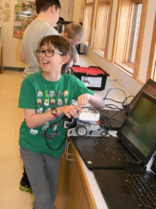 Lone Rock 6th grader Joshua Reisenfeld came to Rich Montoya’s Robotic Class with a head start in robotics. He took a course this summer and has his own project that he works on at home. He is pictured here standing at the counter where all the laptop computers are lined up. Montoya hopes to raise enough money to provide real computer work stations for the students as well as other equipment for the program including computer software programs.