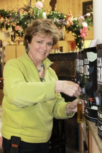 Owner Bunny Robbins dispenses one of the fine olive oils now available at Robbins on Main in Hamilton. Daphne Jackson photo.