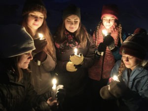 Molly Pickett, Assistant Director and Grief Specialist at Tamarack Grief Resource Center (left), participates in a candle-lighting ceremony where candles are lit to honor the memory of the deceased. At the camps, in the evening, a campfire ritual begins with a candle-lighting ceremony offering an opportunity for each individual to light a candle silently, or with a name or with a story. Once the candles are lit, the group leans down together to light the campfire and discussion may continue, proceeding to thoughts and memories of loved ones and each person’s experience with grief. Then come the snacks, the guitars and the music, and the mood begins to shift to the here and now and to creating new memories of times with supportive others. 
