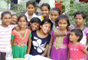 Jessica Brown (seated at center) surrounded by some of the residents of the children’s home in India that she and her mother are raising money for. Photo courtesy of Nancy Brown.