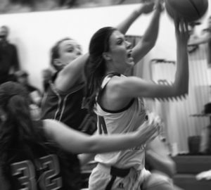 Jamie Burdett of Victor drives through some Drummond players for a lay-up. Jean Schurman photo.